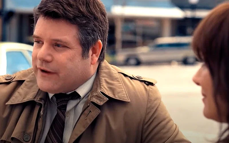 Bob Newby (Sean Astin) talking to Joyce Byers (Winona Ryder) outdoors in Stranger Things