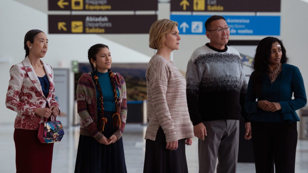 Carol and the unaffected stand in a line