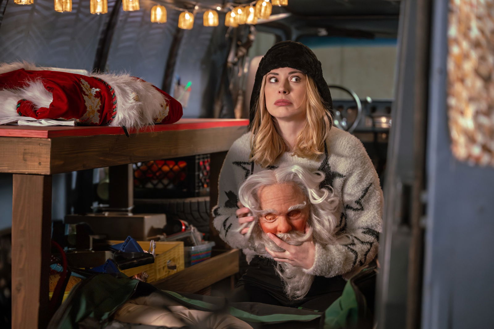 A still from My Secret Santa featuring Taylor holding a Santa mask while sitting in the back of a van