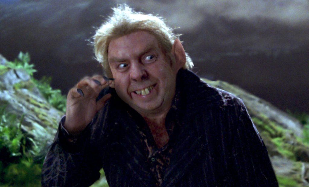 A still from Harry Potter featuring Peter Pettigrew smiling creepily