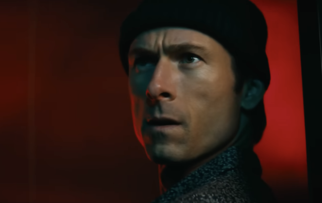 Glen Powell in How to Make a Killing  wearing a beanie 