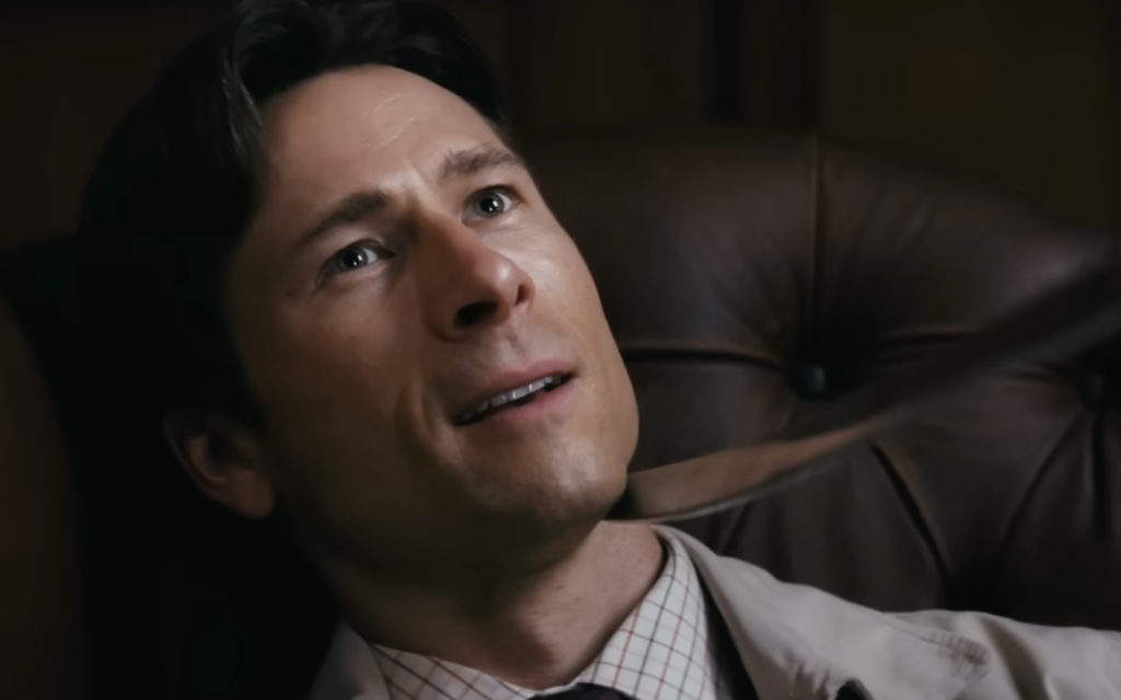 Glen Powell in How to Make a Killing wearing a suit and tie 