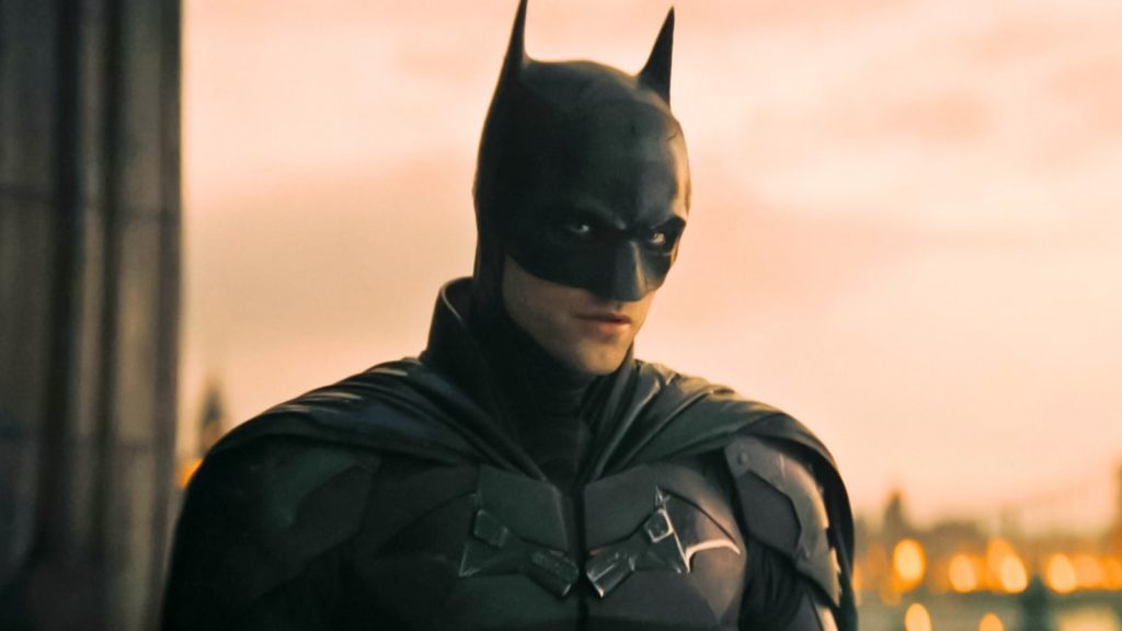 Robert Pattinson as The Batman looking into the camera in a serious expression and will be seen in The Batman 2