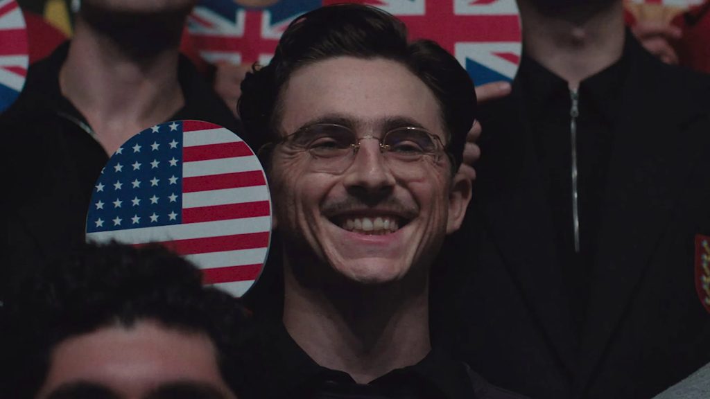 Timothée Chalamet as Marty Supreme, grinning