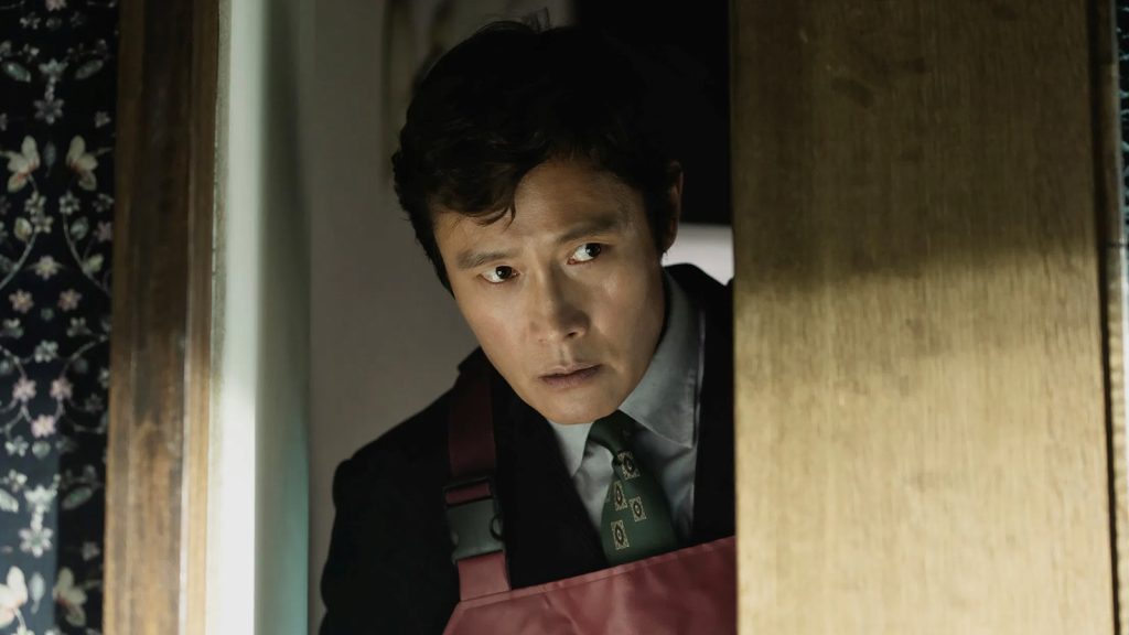 Lee Byung-hun as Yoo Man-su  wearing an apron