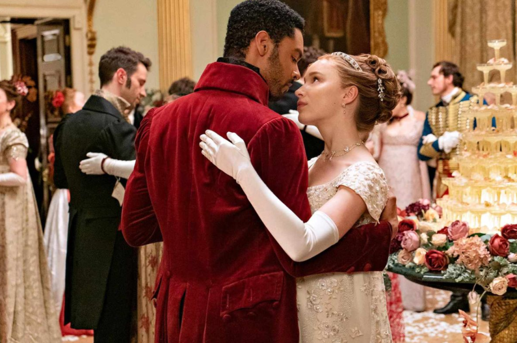 Daphne Bridgerton (Phoebe Dynevor) dancing in a off white gown grabbing Simon Bassett (Regé-Jean Page) and looking up in Bridgerton Season 1 | Credit: Netflix