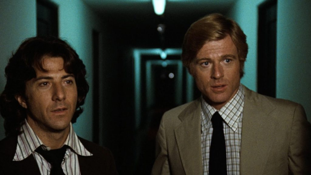 Dustin Hoffman and Robert Redford as Carl Bernstein and Bob Woodward walking a dimly lit corridor in All the President's Men (1976)