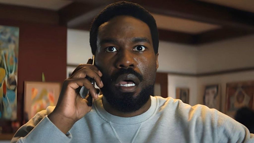 Simon looking surprised holding a phone to his ear in wonder man series