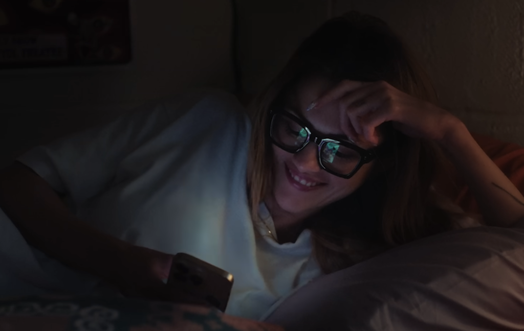 A girl smiling at her phone 