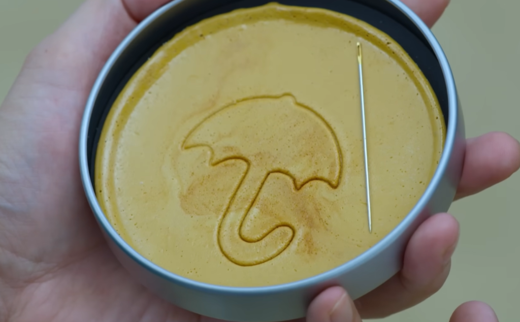 Gi hun getting the toughest shape, Umbrella, in Dalgona game in Squid Game Season 1