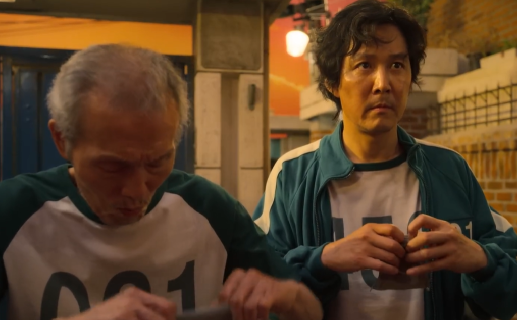 Il-nam and Gi hun receiving their marbles in Squid Game Season 1