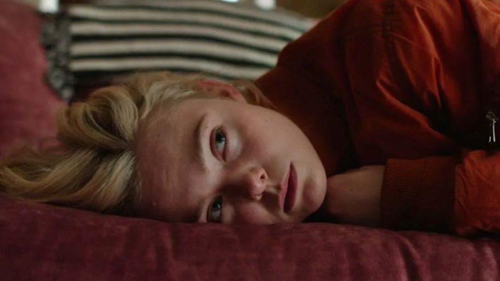 Elle Fanning, lying on couch, in Margo's Got Money Troubles 