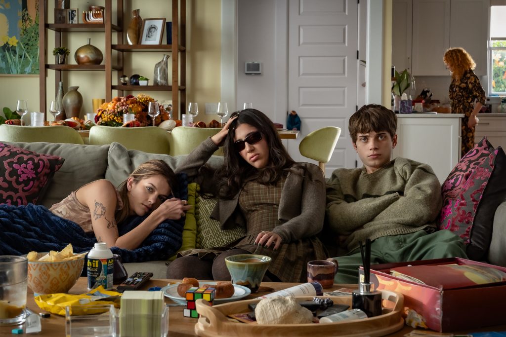 Chloe East as Celeste, Sadie Sandler as Devon, Aidan Langford as Alex  in Roommates, sitting in the couch. 