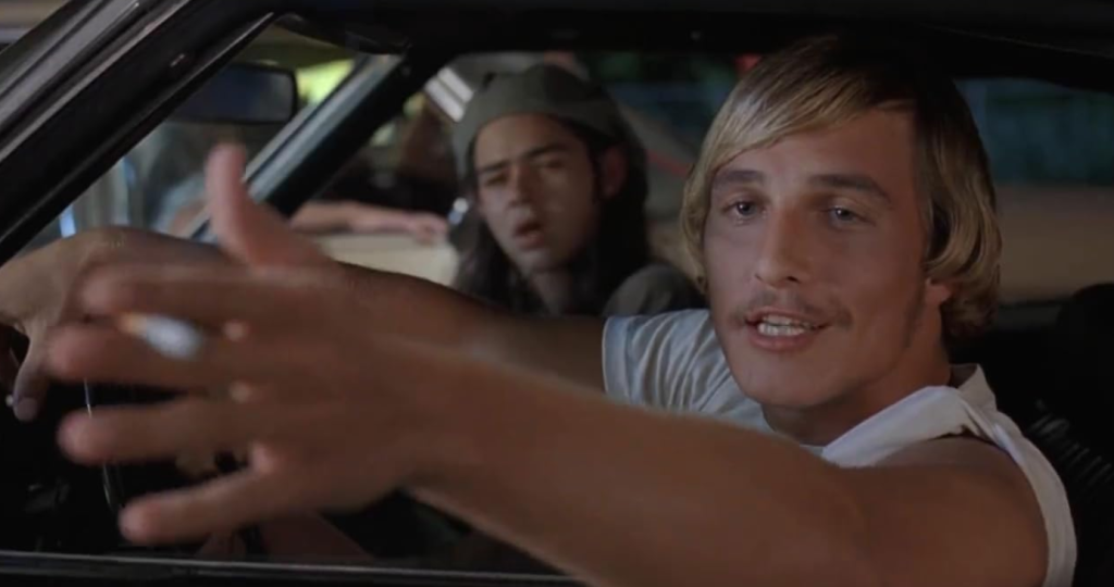 Matthew McConaughey as David Wooderson raising his hand forward in the middle of a conversation in Dazed and Confused