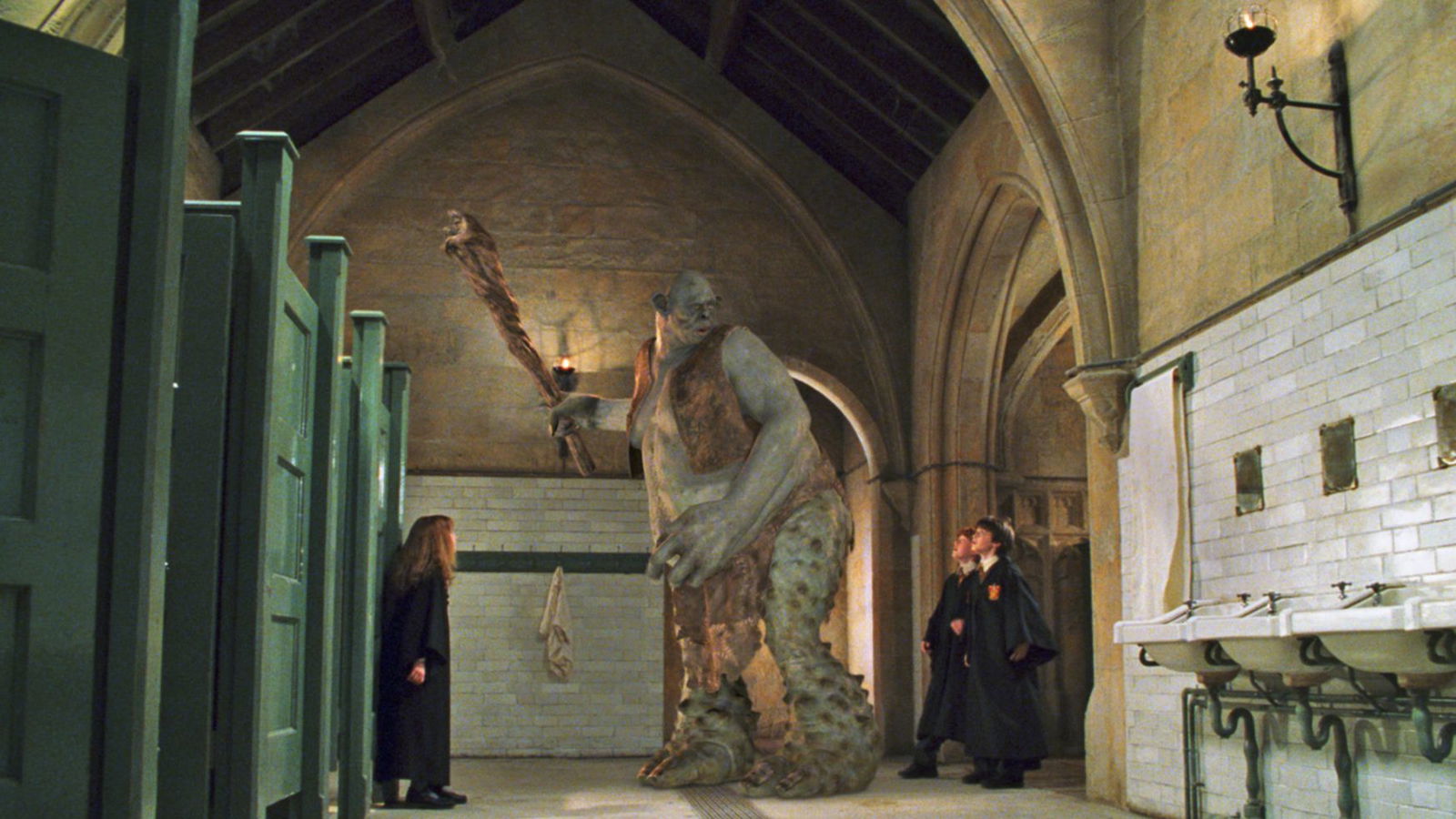 A still from Harry Potter and the Philosopher's Stone featuring Harry, Ron and Hermione with Mountain Troll