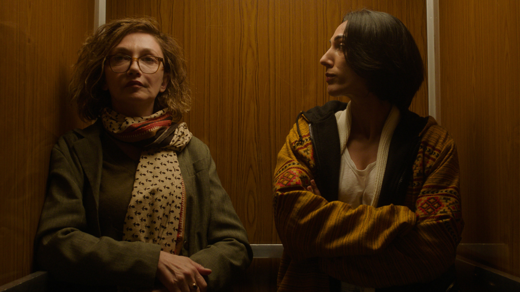 a still from apple tv's unconditional featuring two women in an elevator 