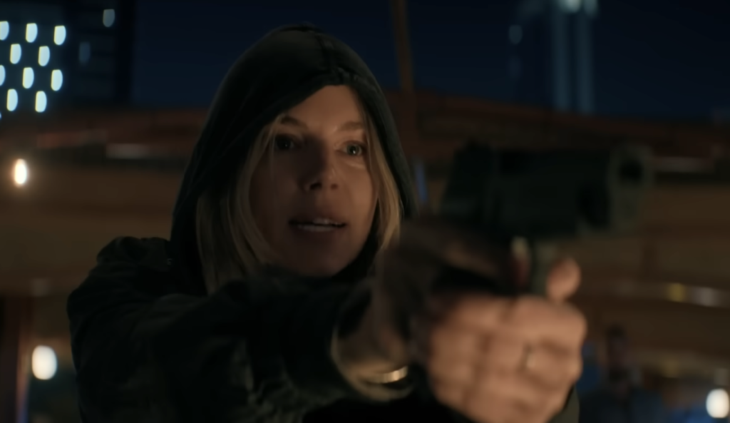Sienna Miller holding a gun