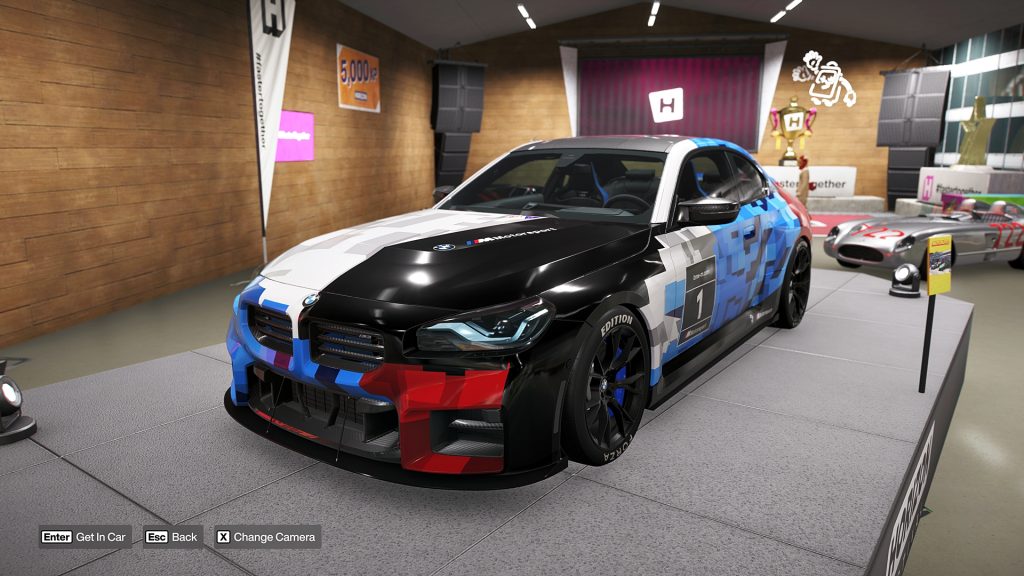 Forza Horizon 6 screenshot showing the BMW M2 Forza Edition presented on a garage podium.