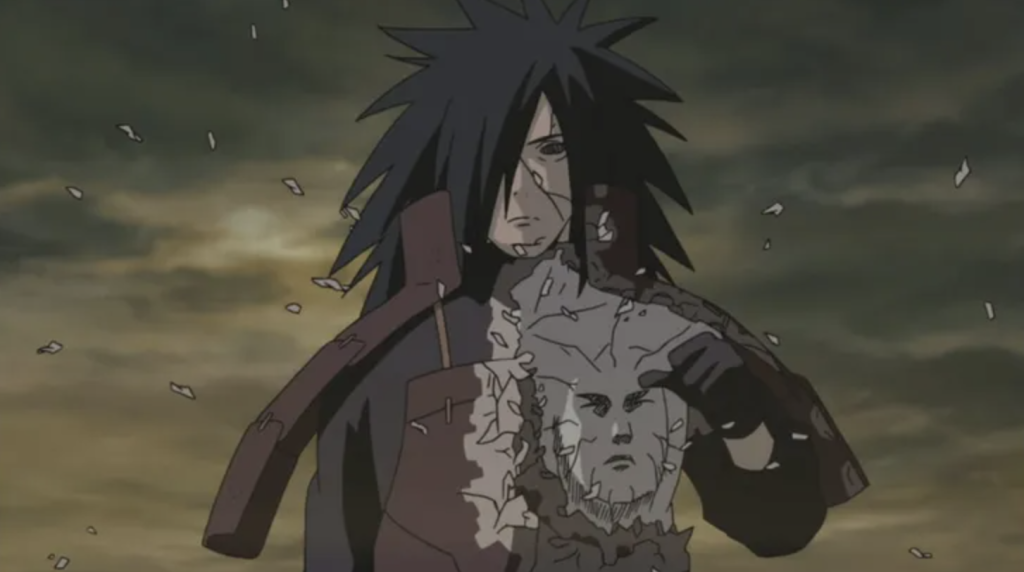 This scene features Madara Uchiha revealing a face on his chest, which belongs to Hashirama Senju and he embedded Hashirama's cells into his own body to enhance his power, allowing him to use Wood Release techniques