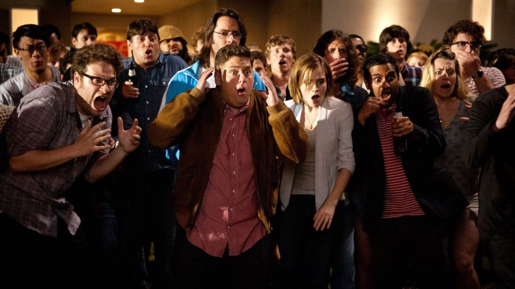 Seth Rogen, Jonah Hill, Emma Watson, and Aziz Ansari among a crowd of party guests reacting in open-mouthed horror outside James Franco's house.