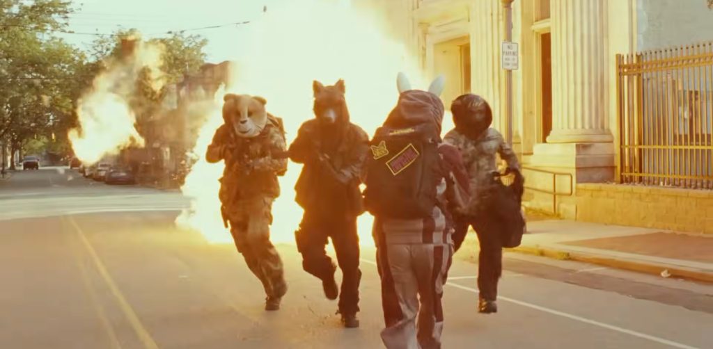 Four masked robbers in animal masks sprinting away from a massive explosion outside a bank on a Pittsburgh street.
