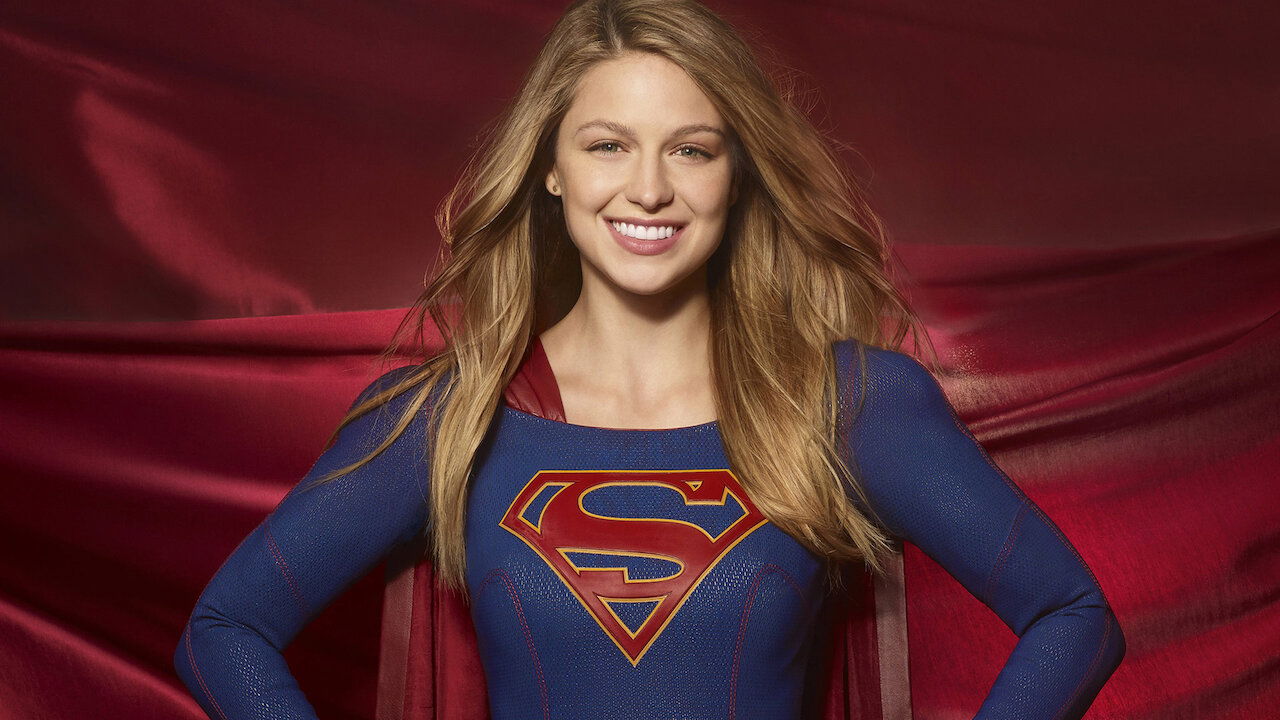 A smiling superhero in a blue-and-red suit with the iconic "S" emblem stands confidently against a flowing red cape backdrop.