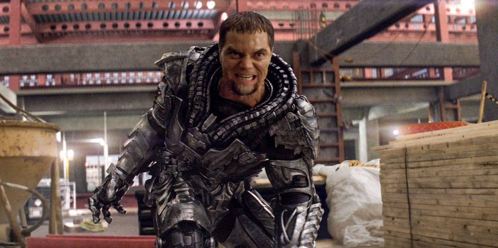 An armored warrior in a metallic battle suit charges forward with an angry expression inside a partially constructed industrial building.