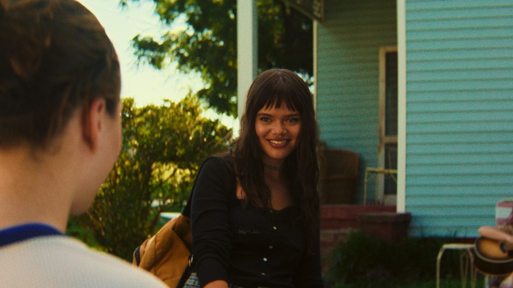 Amber smiles at Natalie outside a house, her friendly expression masking the increasingly unsettling influence she has over the teenager in Cape Fear Episode 4.