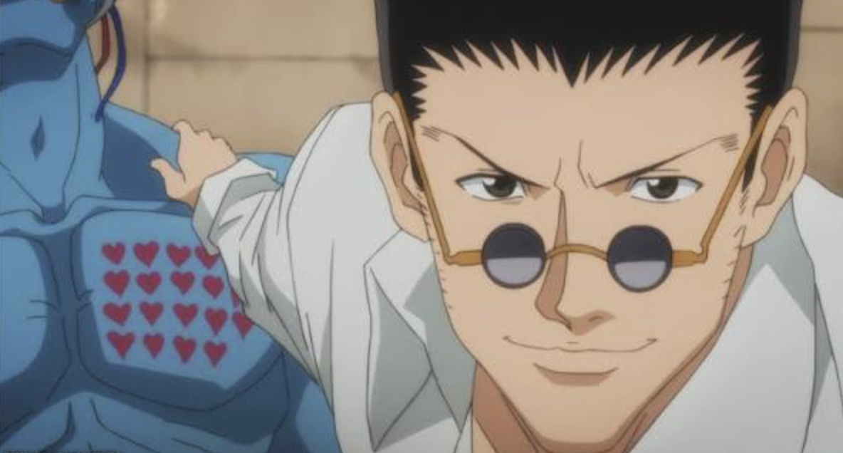 Yoshihiro Togashi's Chapter 430 Update Officially Confirms Hunter x Hunter's Worst Curse Is Finally Over 3 This image features the character Leorio Paradinight from the anime series Hunter × Hunter and he is shown wearing his signature suit and small, round glasses while smiling. | Credits: Madhouse
