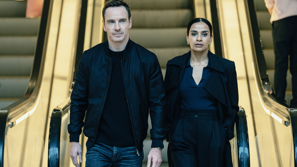 a still from the agency featuring two people walking down the escalator