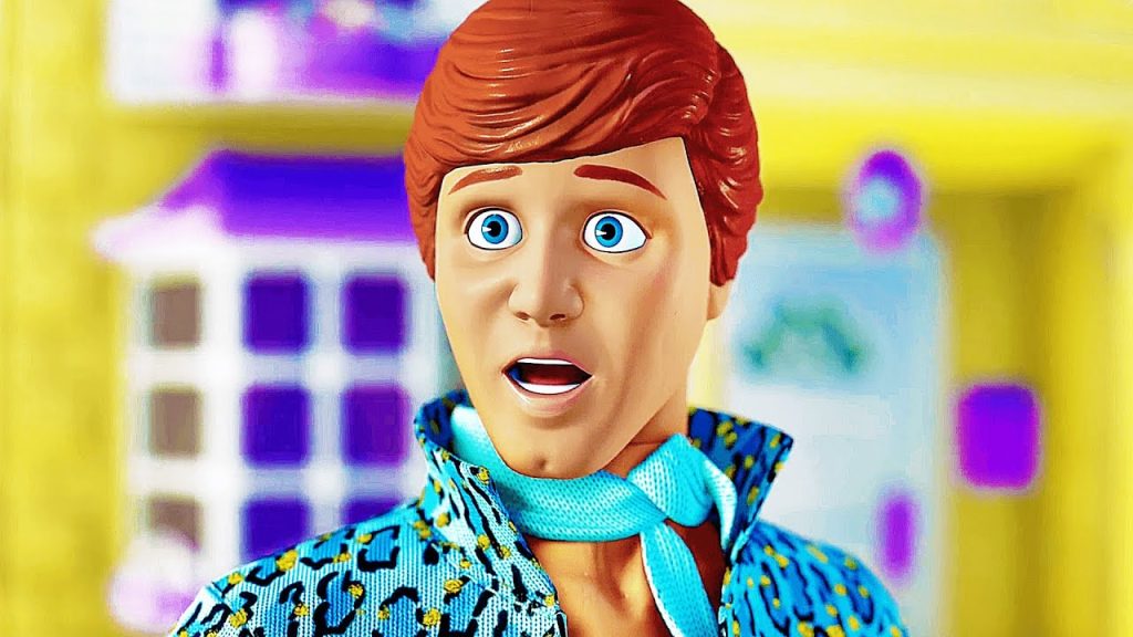 Ken looks shocked with his mouth open and eyes wide in a brightly lit scene from Toy Story 3, wearing a blue patterned shirt and matching scarf.
