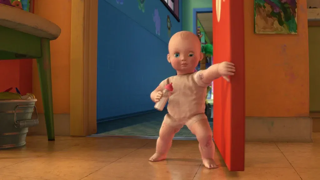 Big Baby stands in a daycare hallway holding a baby bottle while blocking the doorway in a tense scene from Toy Story 3.