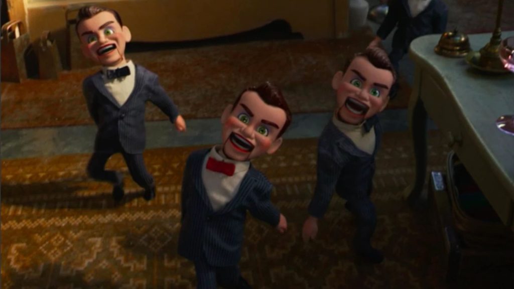Several Benson ventriloquist dummies in striped suits march through an antique store, their unsettling smiles fixed on their faces in Toy Story 4.