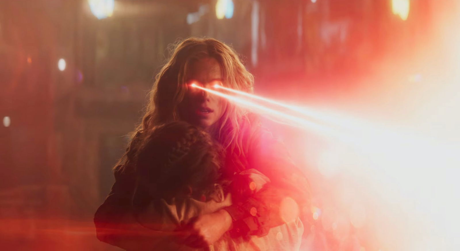 Supergirl uses her heat vision while shielding a child during an action sequence in Supergirl