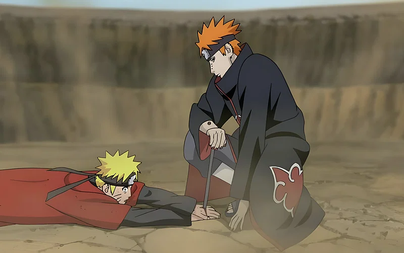 This scene is from Naruto Shippuden and shows Naruto Uzumaki defeated by Pain. Pain has pinned Naruto to the ground using black receivers to restrict his movements and chakra flow.