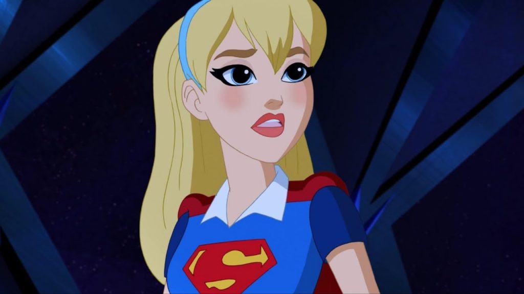 Supergirl, voiced by Anais Fairweather, looks over her shoulder with a concerned expression while wearing her civilian-style blue and red outfit in DC Super Hero Girls.