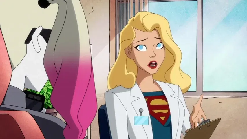 Supergirl, dressed in a white lab coat over her costume, speaks while holding a clipboard as Harley Quinn listens during a conversation in the Harley Quinn animated series.