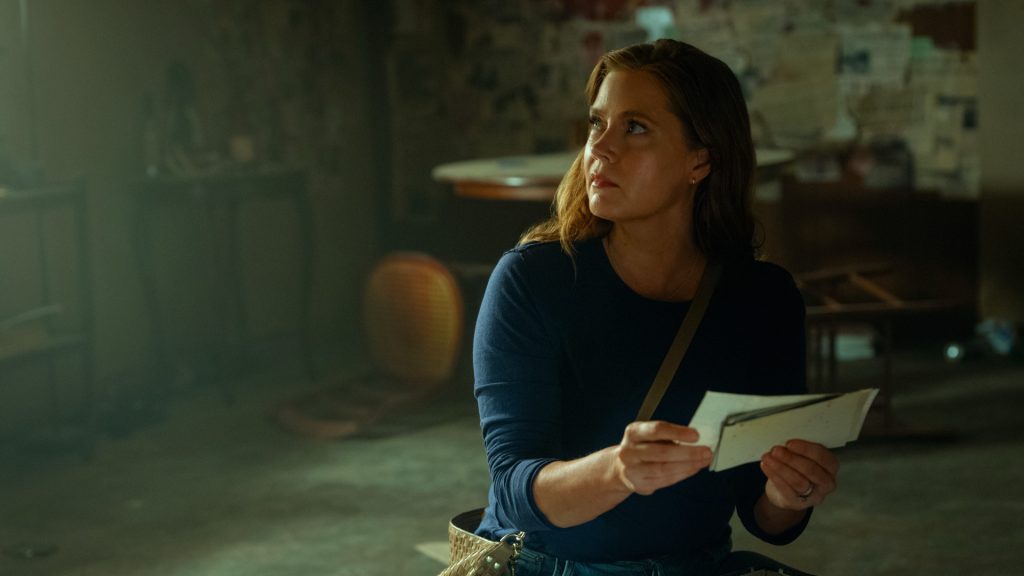 Anna Bowden examines old photographs inside Amy Brancato's trailer as her investigation uncovers another disturbing secret about the Cady family in Cape Fear Episode 9.