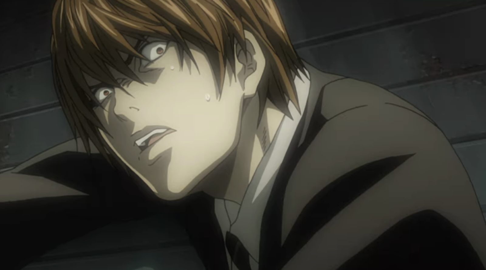This scene shows Light Yagami from Death Note during the series finale when his plans are foiled.