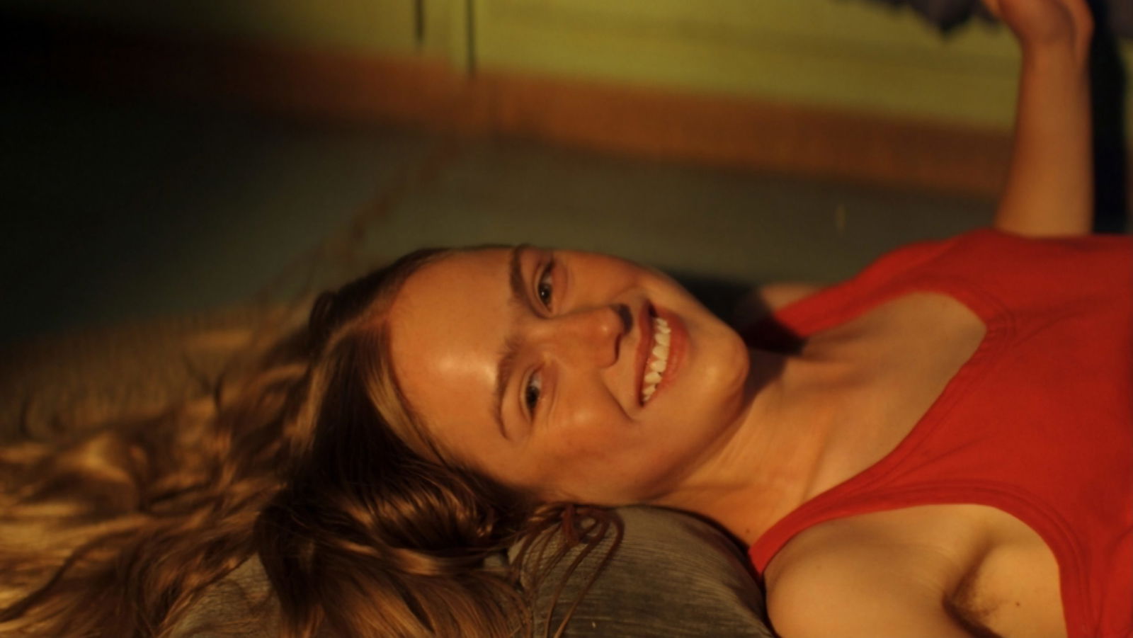 A young woman lays down on the floor in a cabin at Sterling Point