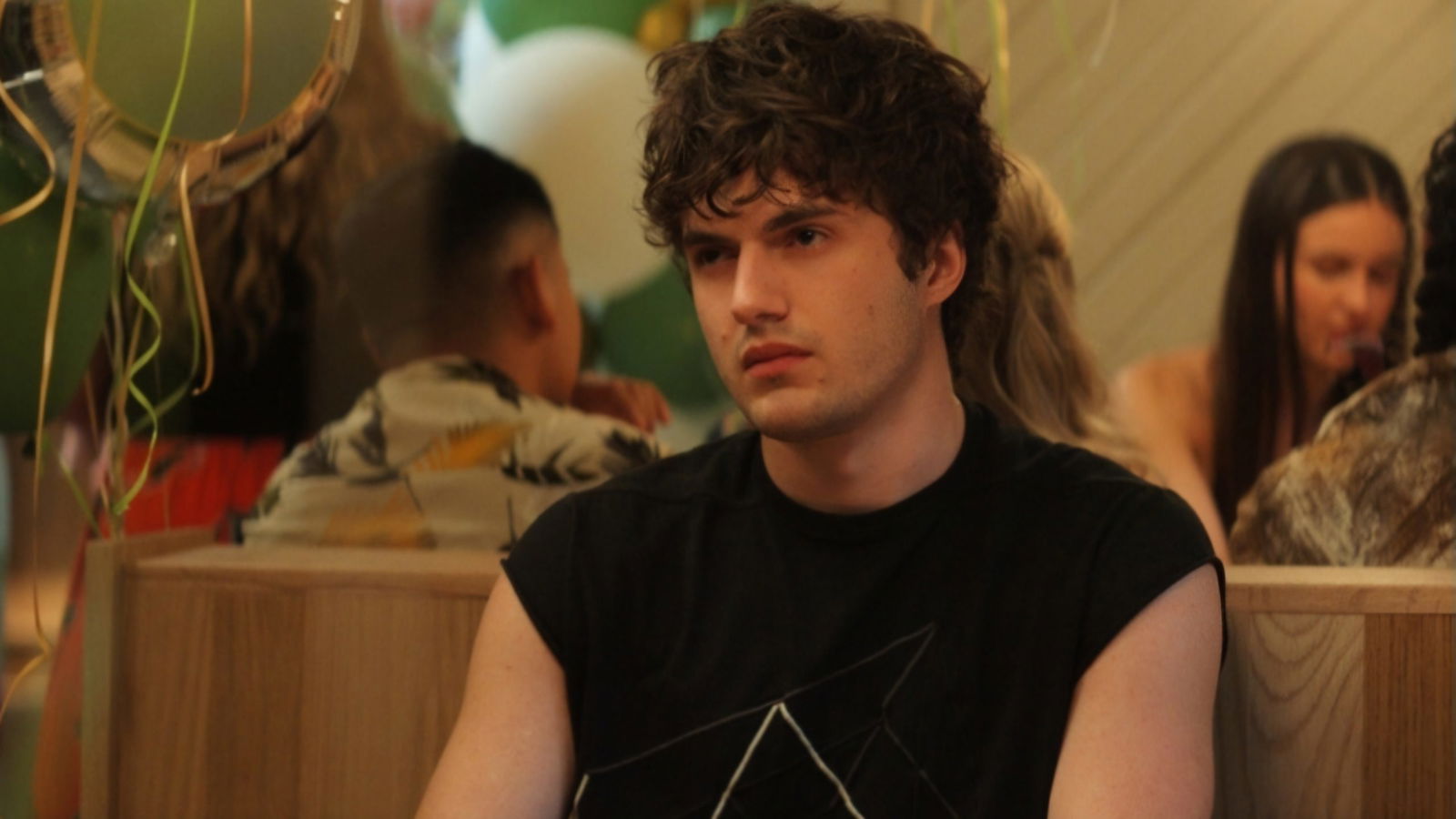 A man who looks like Mark Ruffalo's sons sits in a restaurant in Sterling Point!