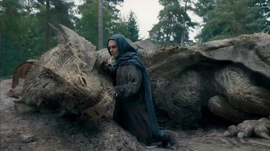 Aegon Targaryen kneels beside the wounded Sunfyre in a forest in House of the Dragon.