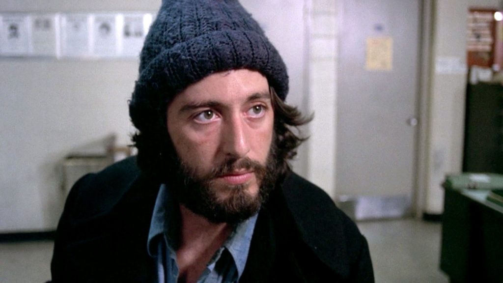 Al Pacino as Frank Serpico wearing a black knit cap and coat in Serpico.