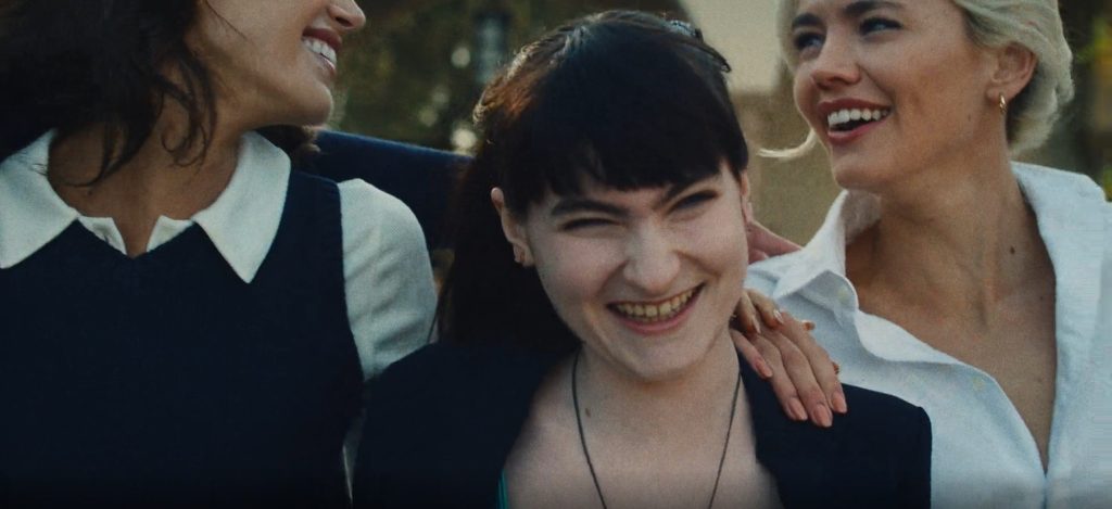 Three young adults smile and laugh together outdoors in a scene from The Shards.