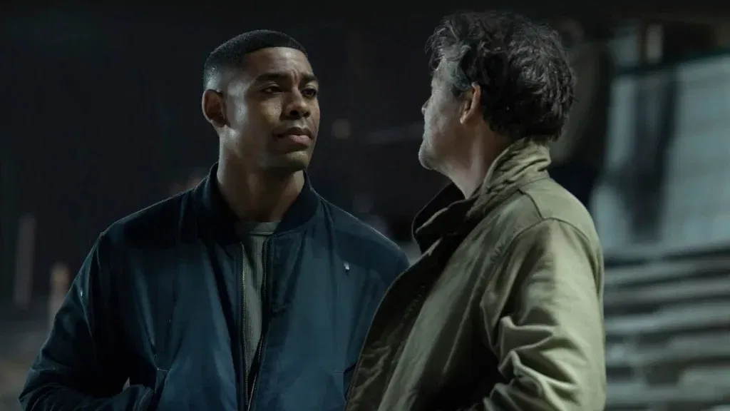 John Stewart (Aaron Pierre) faces Hal Jordan (Kyle Chandler) in a dimly lit parking structure, both men tense as they exchange words in Lanterns Episode 2.
