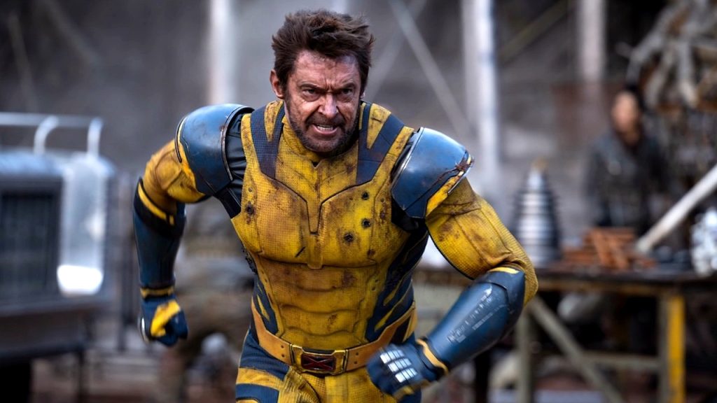 A movie scene featuring Hugh Jackman as Wolverine, wearing his yellow and blue suit from Deadpool & Wolverine.