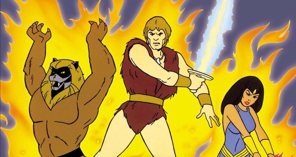 Animated trio stands before a wall of yellow flame — a muscular lion-headed humanoid raises his arms, a bare-chested blond barbarian in a fur tunic wields a glowing sword crackling with energy, and a dark-haired woman in a blue outfit stands ready beside them.