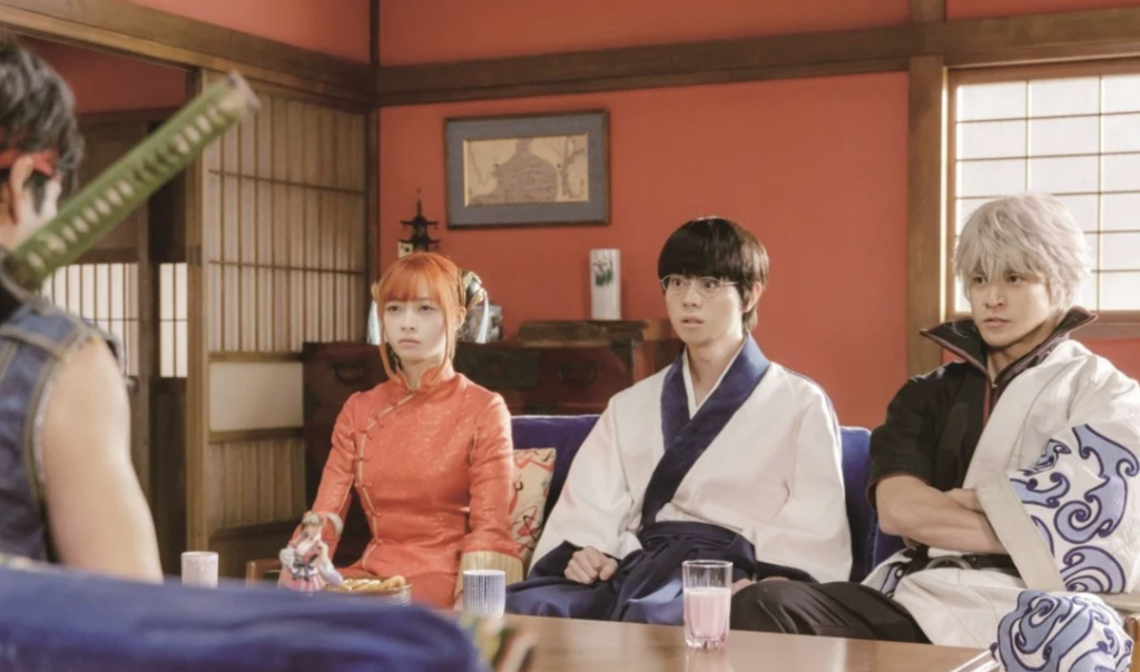  Rules Are Made to Be Broken (2018), featuring the Yorozuya trio—Kagura (played by Kanna Hashimoto), Shinpachi Shimura (played by Masaki Suda), and Gintoki Sakata (played by Shun Oguri)—sitting together in an interior room.