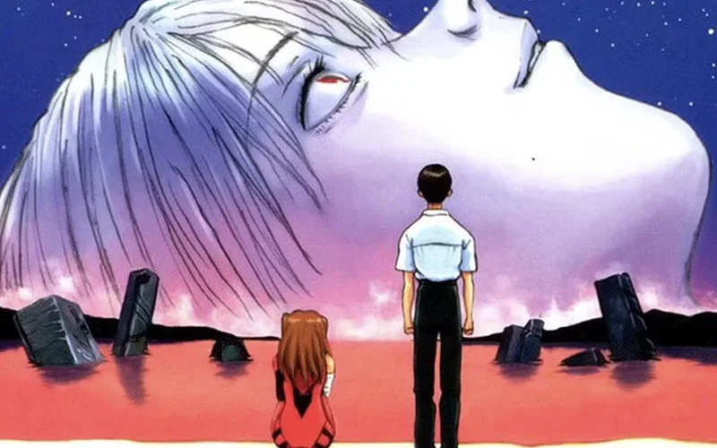 Hình ảnh này thể hiện một cảnh nổi tiếng trong bộ phim hoạt hình The End of Evangelion năm 1997, với hình ảnh đầu khổng lồ của Rei Ayanami nhìn xuống biển đỏ cùng Shinji Ikari và Asuka Langley Soryu.