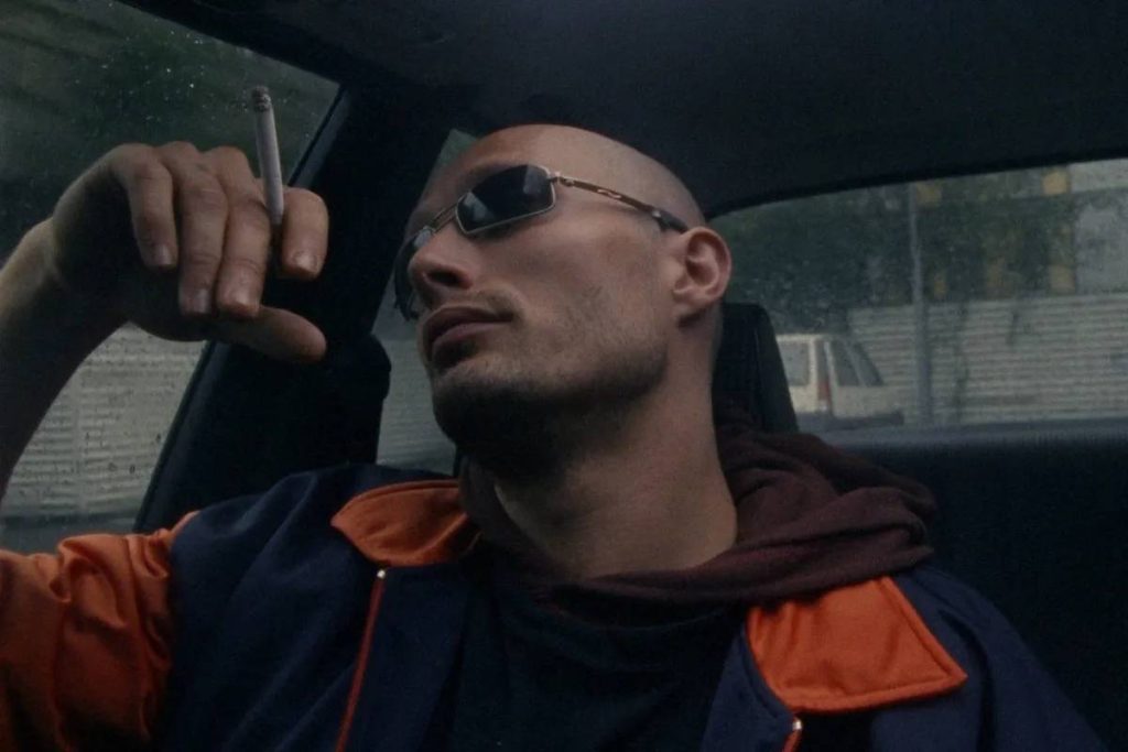 Mads Mikkelsen smoking in a car in Pusher.